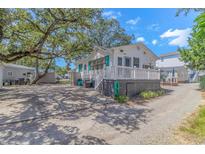 Charming cottage with white siding, teal shutters, and a spacious front porch at 6001- L40 S Kings Hwy., Myrtle Beach, SC 29575