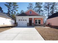 Charming coral exterior boasts a two-car garage and stone accents at 3123 Tiger Tail Rd., Conway, SC 29526