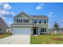 Two-story light green house with a two-car garage and landscaping at 3033 Palma Way, Myrtle Beach, SC 29579