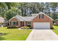 Brick home with two-car garage and landscaped front yard at 3420 Cedar Creek Run, Little River, SC 29566