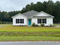 White house with teal door, black windows, and green lawn at 1884 Mount Zion Rd., Loris, SC 29569