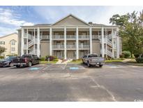 Two-story condo building with ample parking and tree-lined surroundings at 5810 Longwood Dr. # 14-304, Murrells Inlet, SC 29576