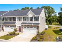 Two-story townhome with beige siding, stone accents, and a two-car garage at 308 Golan Circle # A, Myrtle Beach, SC 29579