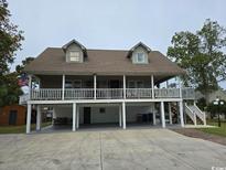 Two-story house with a large deck, ample parking, and a spacious yard at 710 Lakeside Dr., Surfside Beach, SC 29575