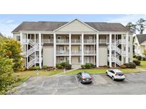 Two-story condo building with ample parking and stair access at 5882 Longwood Dr. # 204, Murrells Inlet, SC 29576