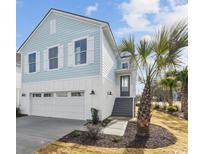 Charming light blue two-story home with a white garage, walkway, and palm trees at 512 9Th Ave. S, North Myrtle Beach, SC 29582