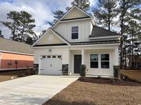 Two-story house with gray and beige siding, stone accents, and a two-car garage at 3125 Tiger Tail Rd., Conway, SC 29526