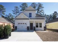 Two-story Craftsman style home with white siding and gray stone accents at 3125 Tiger Tail Rd., Conway, SC 29526