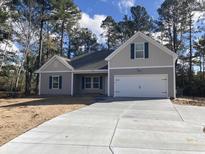 New construction home with a two-car garage and landscaped yard at 1581 Highway 701 South, Loris, SC 29569