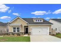 Tan house with white garage door and landscaping at 5042 Selene Ct., Myrtle Beach, SC 29588