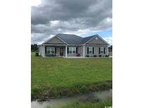 One story home with gray siding, dark metal roof, and large yard at Lot#8 Justice Loop, Loris, SC 29569