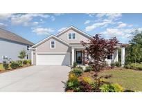 Gray house with white garage door and landscaping at 7046 Shooting Star Way, Myrtle Beach, SC 29579