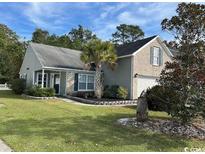 Brick and siding house with landscaping, a palm tree, and a garage at 529 Fort Moultrie Ct., Myrtle Beach, SC 29588