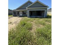 Newly constructed home with gray siding, a two-car garage, and landscaping at 4485 Privetts Rd., Conway, SC 29526