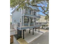 Two-story light blue house with deck, parking underneath, and mature trees at 6001-1122A S Kings Hwy., Myrtle Beach, SC 29575