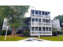 Exterior view of a three-story building with multiple balconies and lush landscaping at 10166 Beach Dr. # 5306, Calabash, NC 28467
