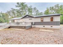 Gray and beige house exterior with large deck and spacious backyard at 7122 Cox Lake Dr., Mullins, SC 29574