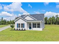 Single-story house with a blue door and landscaped yard at 1174 St. John Rd., Galivants Ferry, SC 29544