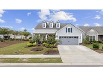Gray house with a two-car garage, landscaping, and a front porch at 6438 Cascata Dr., Myrtle Beach, SC 29572