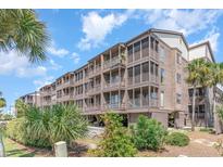 Attractive beachfront condo building with multiple balconies and lush landscaping at 207 N Ocean Blvd. # 241, North Myrtle Beach, SC 29582