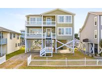 Elevated two-story home with white picket fence at 108 Burlington St. W, Holden Beach, NC 28462