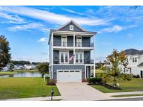 Three-story house with gray siding, white trim, and a two-car garage at 973 Crystal Waterway Dr., Myrtle Beach, SC 29579