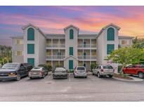 Condo building exterior with parking lot and cars at 1100 Commons Blvd. # 107, Myrtle Beach, SC 29572