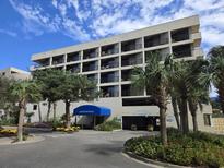 Sand Dunes Villas building exterior, featuring parking and landscaping at 208 74Th Ave. N # 2324, Myrtle Beach, SC 29572