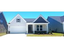 Two-story Craftsman style home with white siding, gray roof and stone accents at 1131 Nw Rosefield Way, Calabash, NC 28467