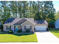 House exterior featuring a two-car garage and well-manicured lawn at 378 Oak Crest Circle, Longs, SC 29568