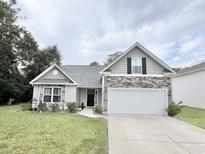 Two-story house with gray siding, stone accents, and a two-car garage at 230 Mint Ct., Little River, SC 29566