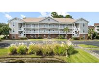 Two-story condo building with ample parking and lush landscaping at 5750 Oyster Catcher Dr. # 1134, North Myrtle Beach, SC 29582