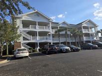 Three-story building exterior with parking lot at 5801 Oyster Catcher Dr. # 413, North Myrtle Beach, SC 29582