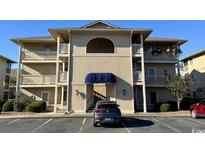 Tan three-story building with blue awning and parking lot at 4278 Pinehurst Circle # W2, Little River, SC 29566
