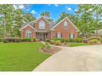 Brick house with manicured lawn and circular driveway at 676 Oxbow Dr., Myrtle Beach, SC 29579