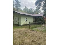 Light green house with brown roof and American flag at 708 Grices Ferry Ct., Mullins, SC 29574