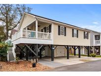 Elevated light beige house with a garage and a deck at 6001 - 8039 S Kings Hwy., Myrtle Beach, SC 29575