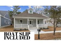 Gray house with white trim, front porch, and a landscaped yard at 157 Bridge View Rd., Georgetown, SC 29440