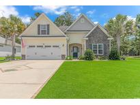 Beautiful two-story home with a two car garage and landscaped lawn at 4157 Charleston Oaks Dr, Loris, SC 29569