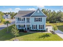 Two-story light-blue house with a white garage and well-maintained lawn at 1315 Bermuda Grass Dr., Myrtle Beach, SC 29579