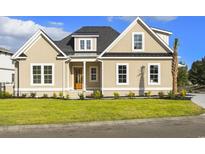 Tan two-story house with a gray roof, landscaping, and a two-car garage at 2313 Summersweet Ln., Myrtle Beach, SC 29579