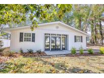 Charming white cottage with black shutters and a spacious front yard at 615 1St Ave. N, Surfside Beach, SC 29575