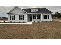One-story home with gray siding, black windows, and front porch at 3854 Red Bluff Rd., Loris, SC 29569