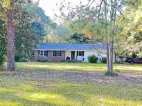 Ranch style home with brick and white siding, situated on a large lot at 1064 Heritage Rd., Loris, SC 29569