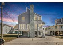 Elevated beach house with gray siding and two-car garage at 206 56Th Ave. N, North Myrtle Beach, SC 29582