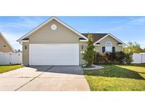 Tan house with a white garage door and manicured lawn at 481 Irees Way, Longs, SC 29568