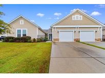 Tan two-story home with two-car garage and landscaped lawn at 1562 Palmina Loop # B, Myrtle Beach, SC 29588