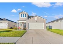 Two-story home with attached garage and landscaping at 1099 Saltgrass Way, Myrtle Beach, SC 29588
