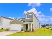 Two-story house with green siding and a white garage door at 420 Ribbon Rail Way, Loris, SC 29569