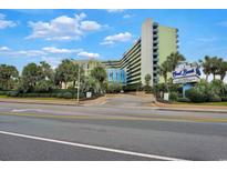 Exterior view of the Coral Beach building with palm trees at 1105 S Ocean Blvd. # 106, Myrtle Beach, SC 29577